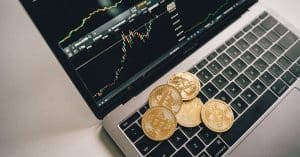 golden-bitcoin-coins-placed-on-a-laptop-keyboard-with-trading-chart-displayed-on-the-screen